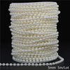 A spool of ivory pearl beads used for garland decoration, showing the beads laid out and a loose strand.