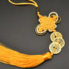 An I Ching copper coin feng shui charm with a handwoven knot and orange silk tassel.