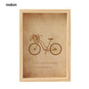 A light wooden photo frame with a vintage illustration of a bicycle and text inside.