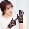 A woman wearing black sheer lace gloves, posing for a photo.