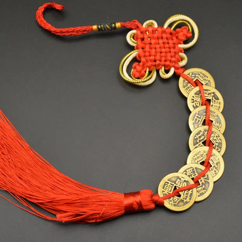A set of I Ching copper coins used as Feng Shui charms with a handwoven knot and red thread.
