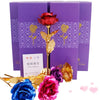 A bouquet of artificial roses with gold foil accents displayed in purple gift boxes.