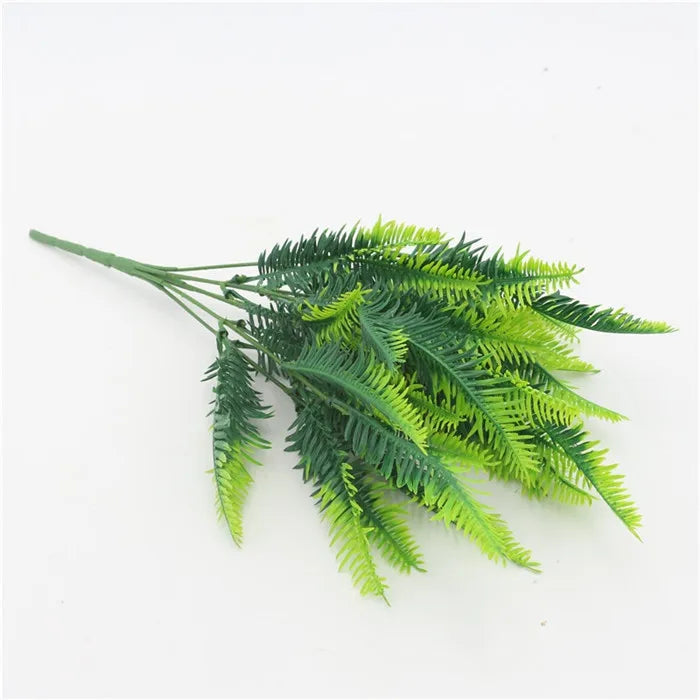 A sprig of bright green artificial fern leaves and fronds.