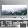 A long marble table with chairs in front of a large framed photograph of a misty forest.