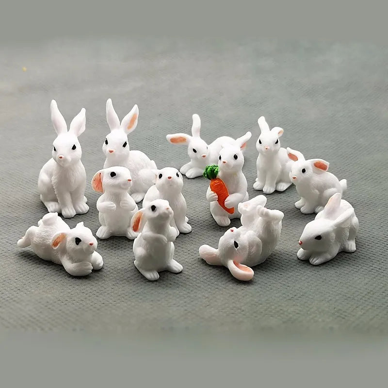 A collection of white miniature rabbit figurines in various poses and sizes for garden or craft decor.