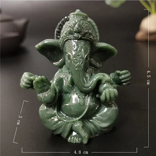 Handcrafted green Buddha statue with a serene expression sitting in a meditative pose.