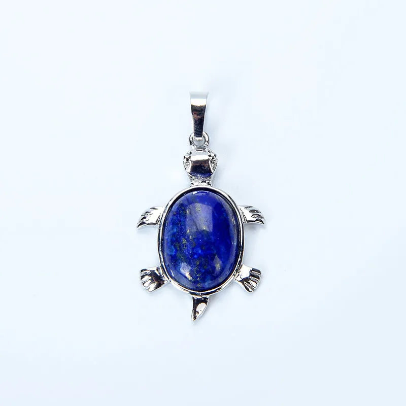 A silver pendant necklace featuring a deep blue lapis lazuli stone shaped like an animal.