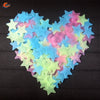 A heart shape made of glow-in-the-dark star wall stickers in various pastel colors like blue, pink, and green.