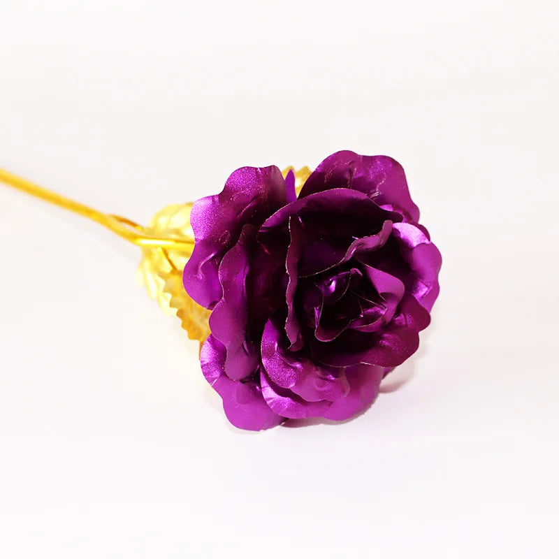 A deep purple artificial rose with a gold foil stem and leaves.