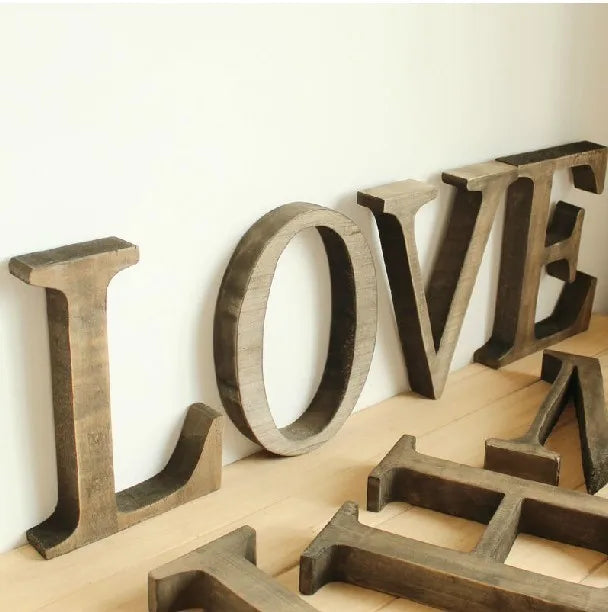 A collection of vintage wooden alphabet letters spelling LOVE used for home decor or events.