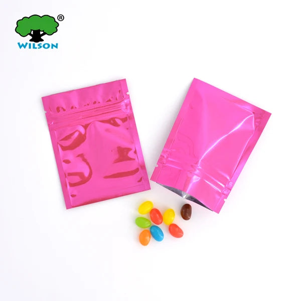 Pink foil zip bags containing colorful candies are displayed next to a Wilson logo.