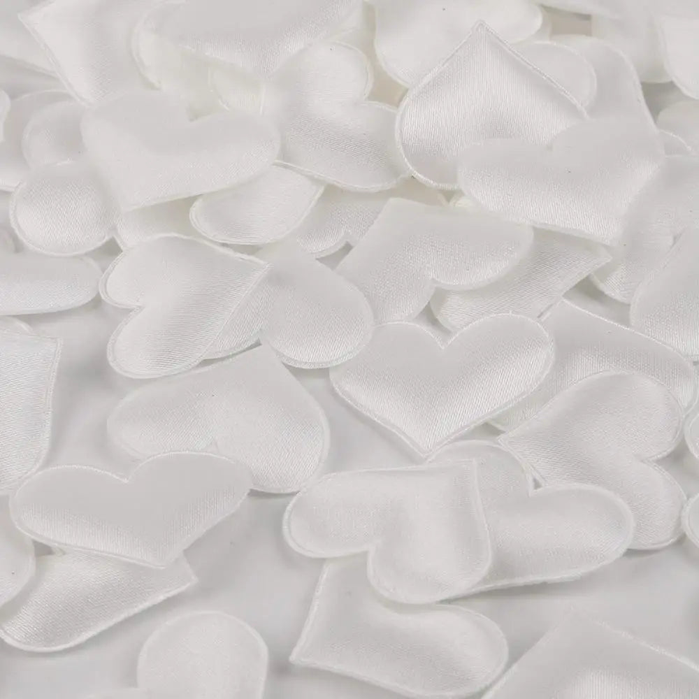 White heart-shaped sponge confetti scattered on a white surface