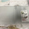A clear plastic photo album titled Pieces of Moment for instant film, lying on a wooden surface.