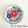 A light blue floral plate with pink, purple, and red flowers and a gold rim.