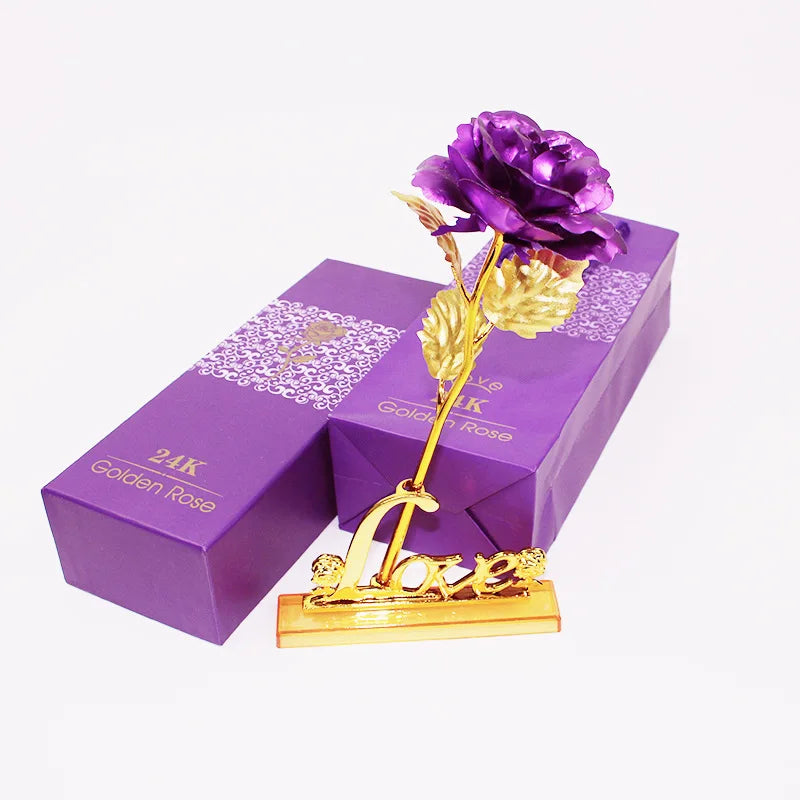 A purple artificial rose in a gold foil frame displayed on a purple box.