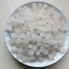 A pile of white natural unrefined sea salt crystals on a white plate.