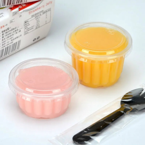 Five clear plastic dessert cups with lids containing yellow and pink jelly desserts