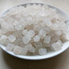 A pile of white natural unrefined sea salt crystals in a white dish.