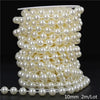 A spool of ivory pearl beads used for garland decoration, showing the beads coiled and a finished strand.