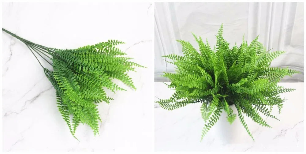 A sprig of bright green artificial fern leaves and fronds displayed on a white marble surface.
