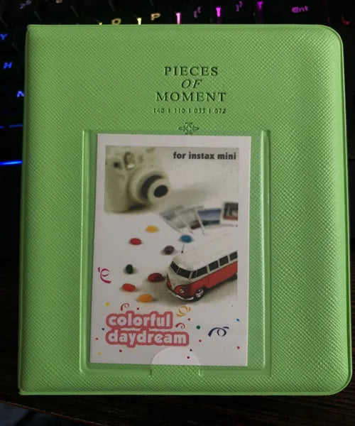 A lime green compact photo album titled Pieces of Moment featuring a colorful daydream theme.
