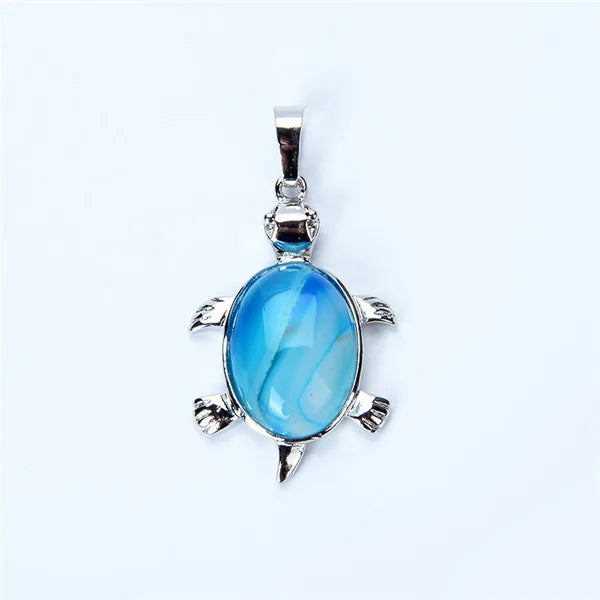 Silver pendant necklace featuring a polished blue-green natural stone shaped like an animal.