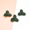 Three artificial green leaves for crafts and home decor displayed on a light pink background.