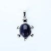 Silver pendant necklace featuring a polished dark blue stone shaped like an animal.