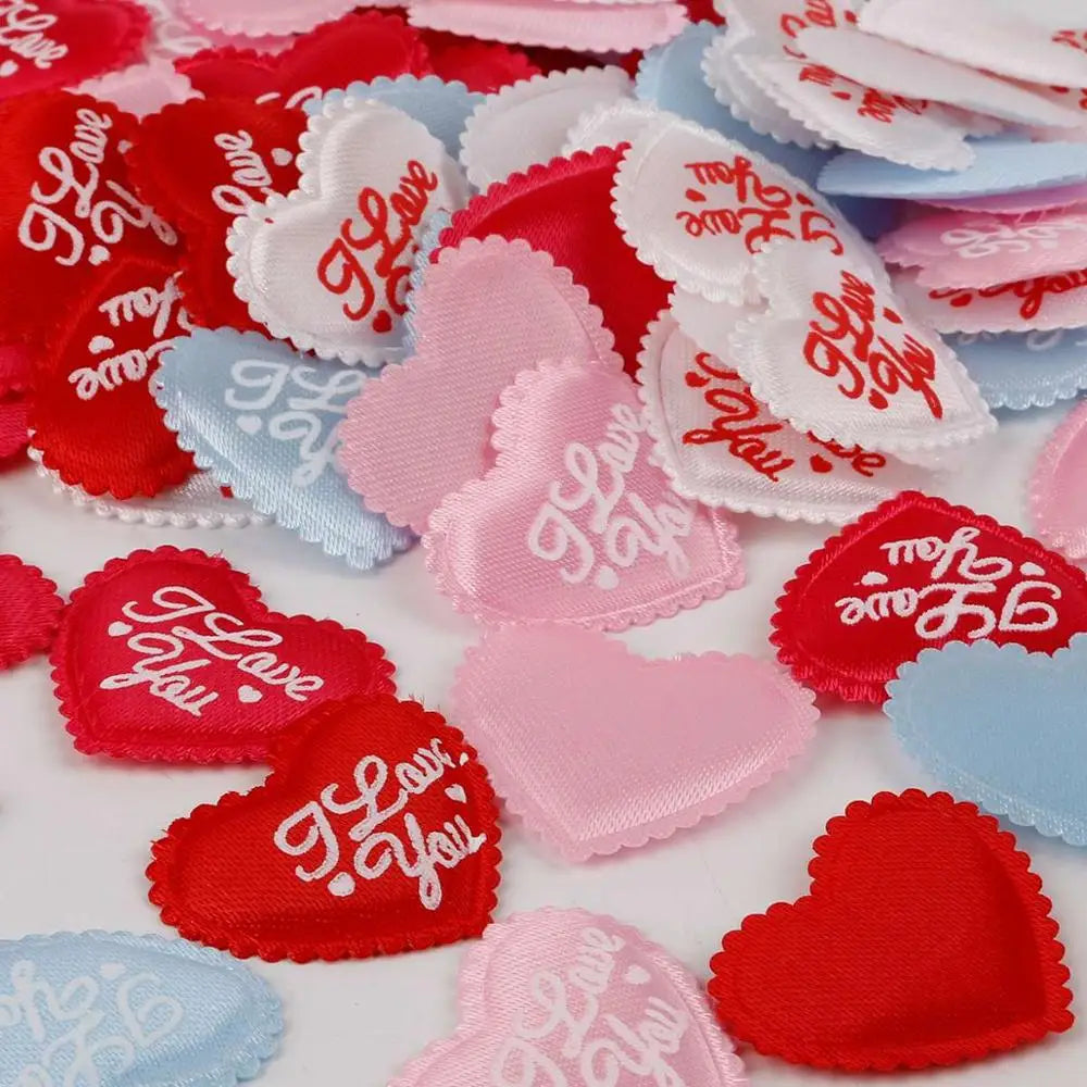 A variety of heart-shaped sponge confetti in red, pink, and blue colors scattered on a white surface.