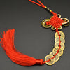 A red thread charm featuring a copper coin and handwoven knot, used as an I Ching Feng Shui item.