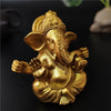 Golden handcrafted statue of Ganesha sitting in a meditative pose