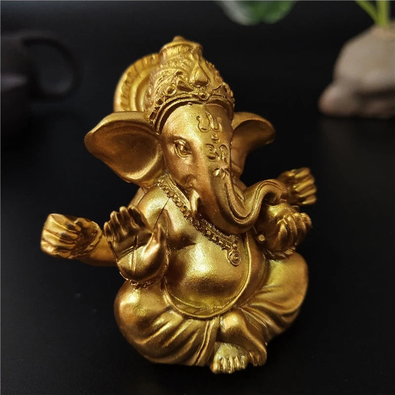 Golden handcrafted statue of Ganesha sitting in a meditative pose