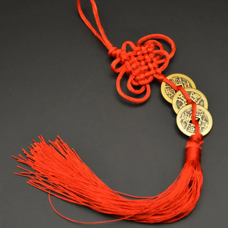 Orange thread charm featuring a handwoven knot and copper coins for I Ching Feng Shui