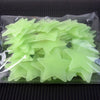 A clear plastic package containing a 50 pack of glow-in-the-dark lime green star wall stickers.