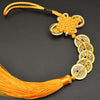 An I Ching copper coin feng shui charm with a handwoven knot and orange silk thread.