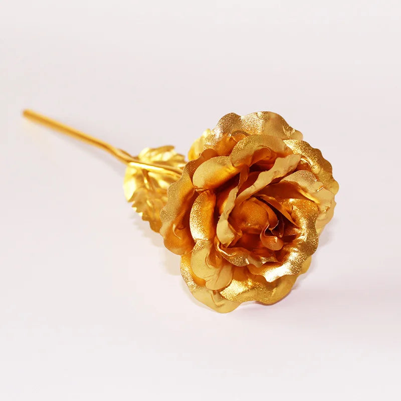 A single artificial rose made of 24k gold foil attached to a thin golden wire.