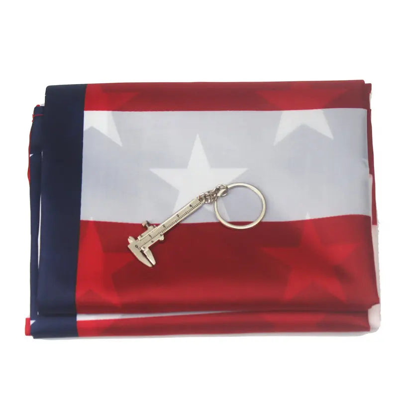 A folded red, white, and blue American flag banner with a gold-colored replica firearm displayed on the fabric.
