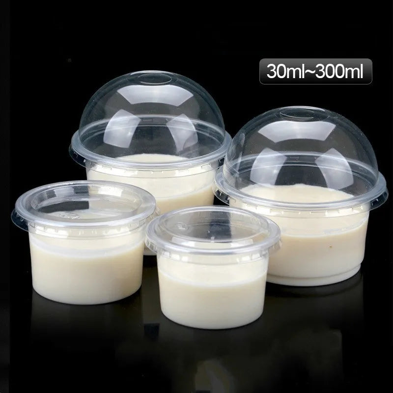 Five clear disposable dessert cups with lids containing a white creamy substance, packaged for serving.