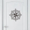 A black nautical compass rose design centered on a white door panel.