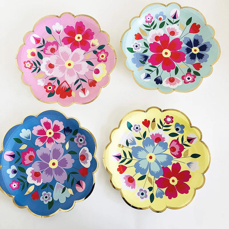 A set of five colorful floral disposable plates featuring pink, blue, and red flowers on white and pastel backgrounds.