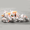 A collection of small white rabbit figurines arranged around an orange carrot.