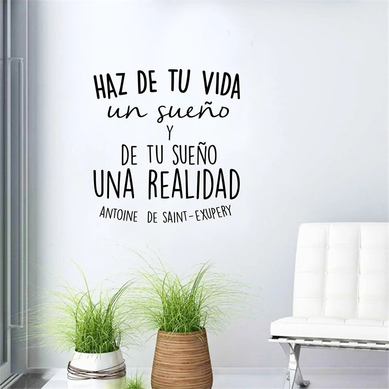 Black text inspirational quote on a white wall: Haz de tu vida un sueño y de tu sueño una realidad.