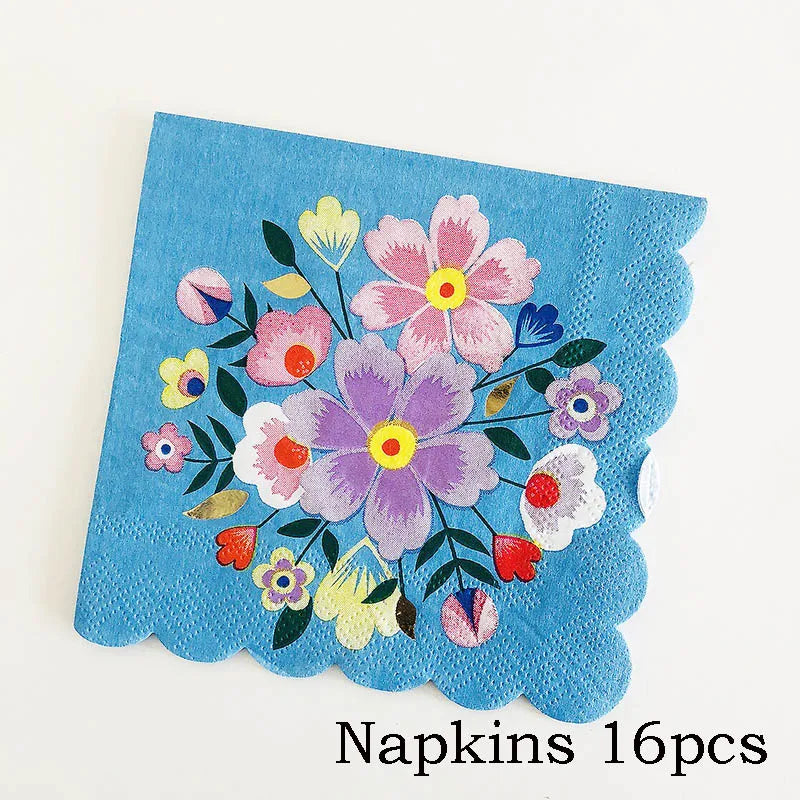 A teal napkin featuring a colorful floral pattern of pink, purple, and yellow flowers.