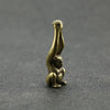A vintage brass monkey key chain charm sculpted in a grasping pose.