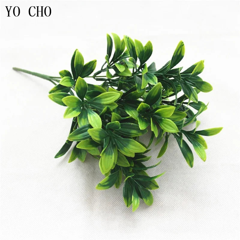 A sprig of green artificial fern leaves and foliage for decoration.