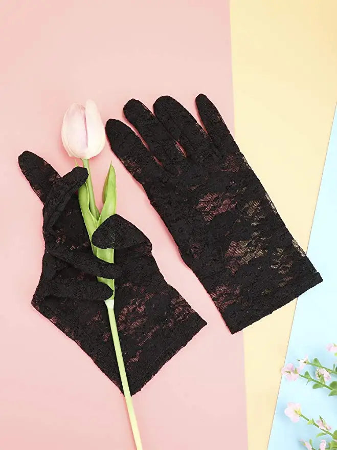 Black sheer lace gloves with a pink tulip flower on a light pink background.