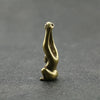 A vintage brass monkey key chain charm shaped like a monkey, resting on a dark gray surface.