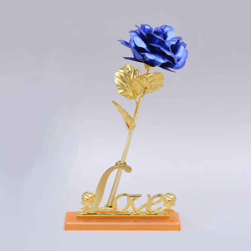 A gold foil artificial rose bouquet with a blue rose on a stem, featuring the word Love below.