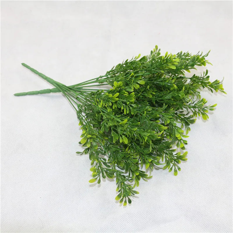 A bunch of bright green artificial fern and leaf sprigs for decoration