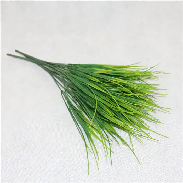 A sprig of bright green artificial fern and leaf for decoration.